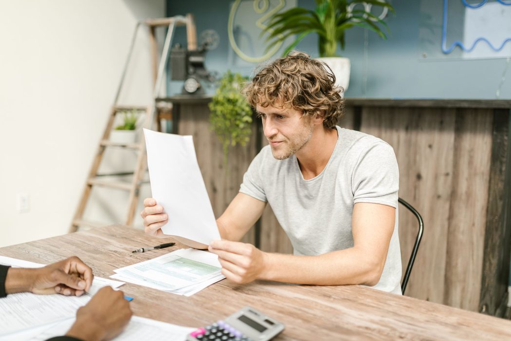 Person reviewing paperwork and notes at a desk